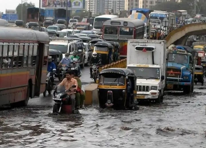 Buses, auto-rickshaws and motorbikes in a flooded Mumbai street